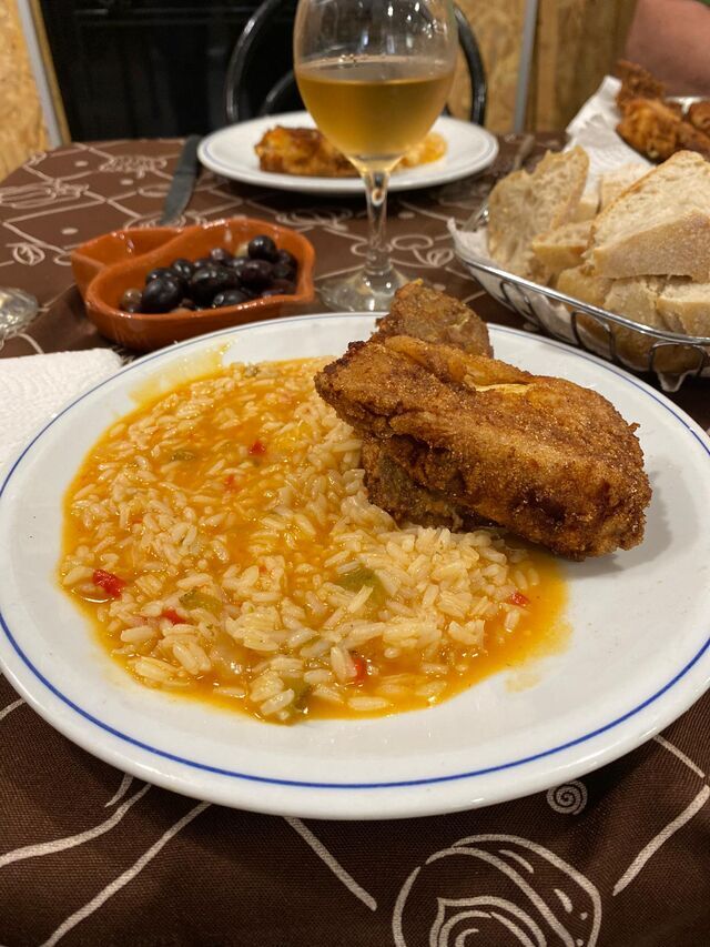 Prato de arroz com carne frita e copo de vinho branco
